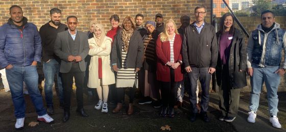 Members of the Borough of Sanctuary Grants Programme panel standing together outside by a wall