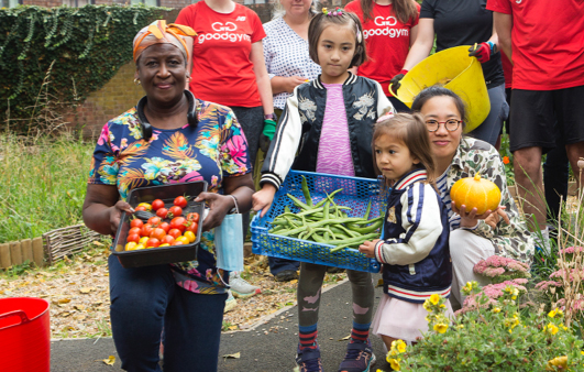 People holding vegetables in a community garden