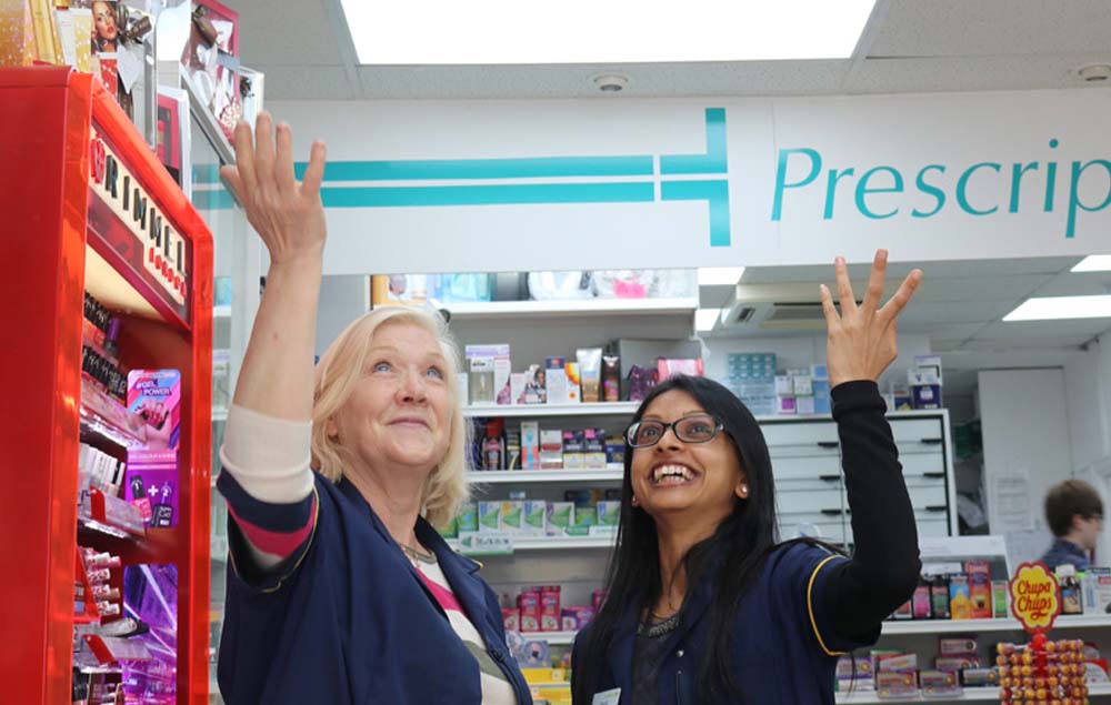 Women pointing to LED lights in pharmacy