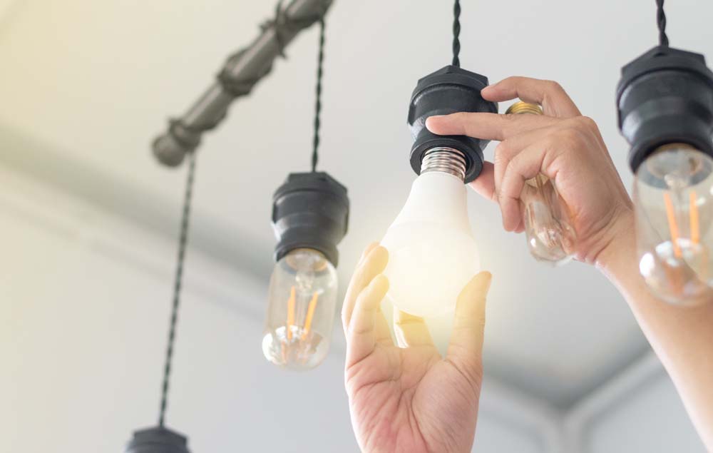 Lightbulb being changed to an energy efficient bulb