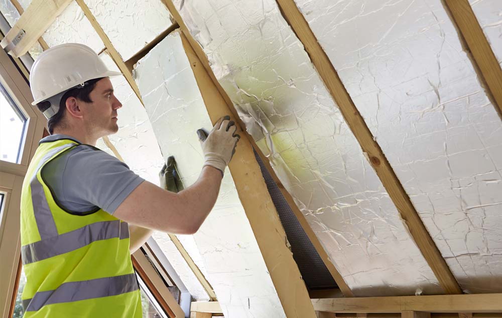 Man installing insulation in home